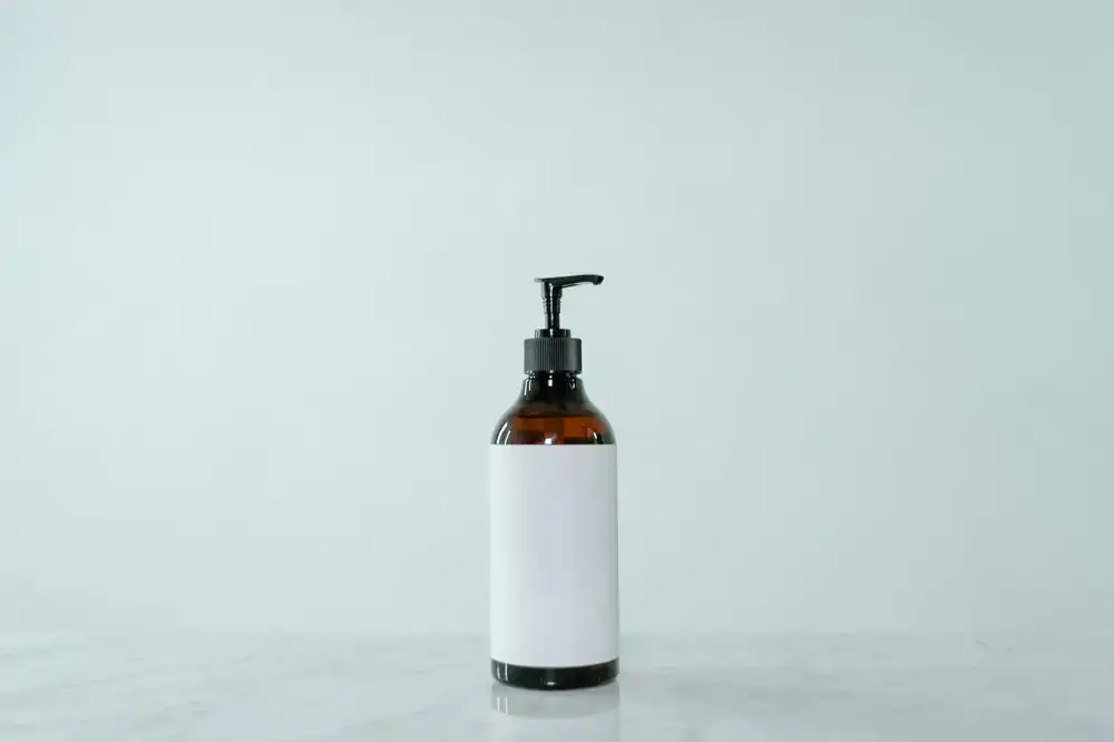 Pumping liquid soap into a reusable glass bottle